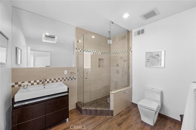 bathroom with walk in shower, vanity, and toilet