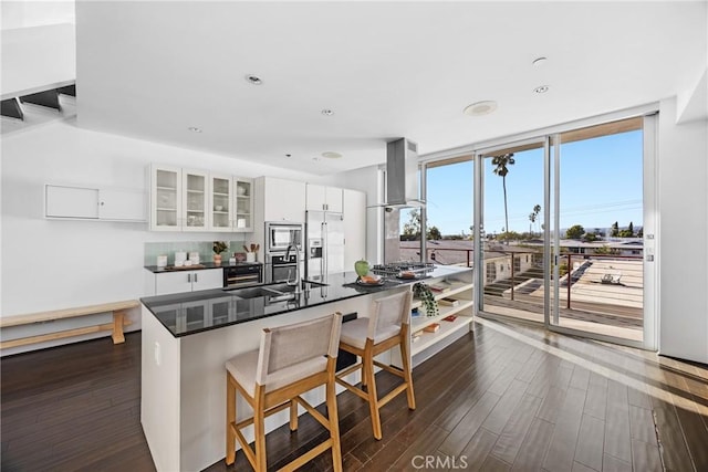 kitchen featuring extractor fan, white cabinetry, a wall of windows, stainless steel appliances, and dark wood-type flooring