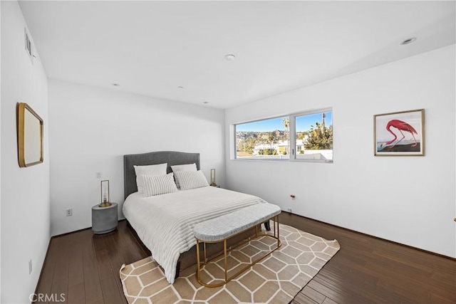 bedroom with dark hardwood / wood-style floors