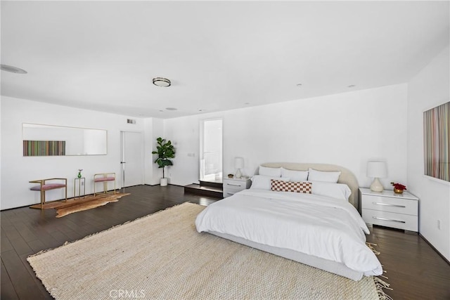 bedroom with dark hardwood / wood-style floors