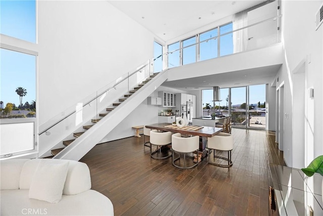 dining space with a high ceiling and dark wood-type flooring