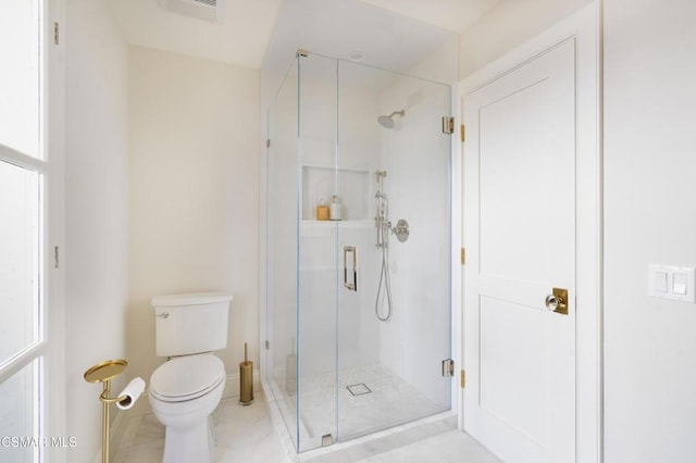 bathroom with toilet and an enclosed shower