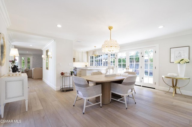 dining space with crown molding, a wealth of natural light, and light wood-type flooring