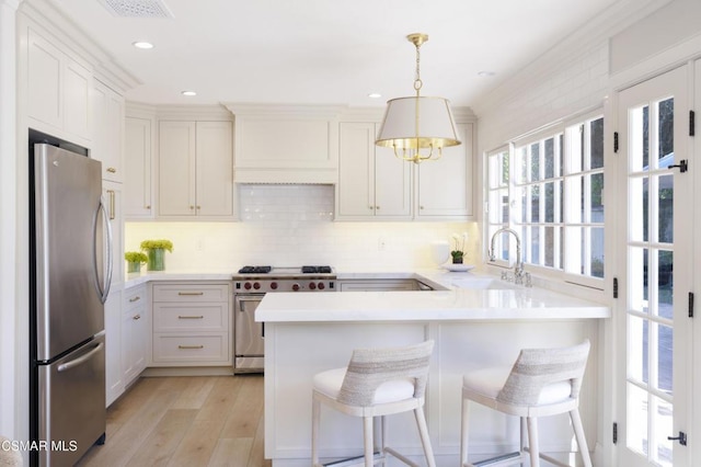 kitchen featuring appliances with stainless steel finishes, sink, pendant lighting, and a kitchen breakfast bar