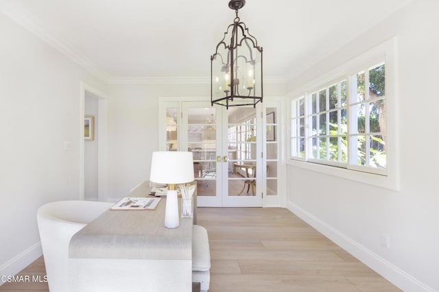 interior space featuring french doors, ornamental molding, a chandelier, and light hardwood / wood-style floors