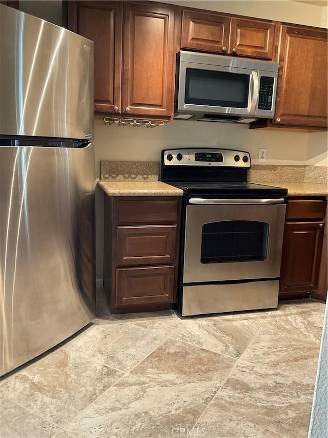 7405 Charmant Dr Unit 2320, San Diego, CA 92122 - kitchen featuring stainless steel appliances, light countertops, and light stone finish floors