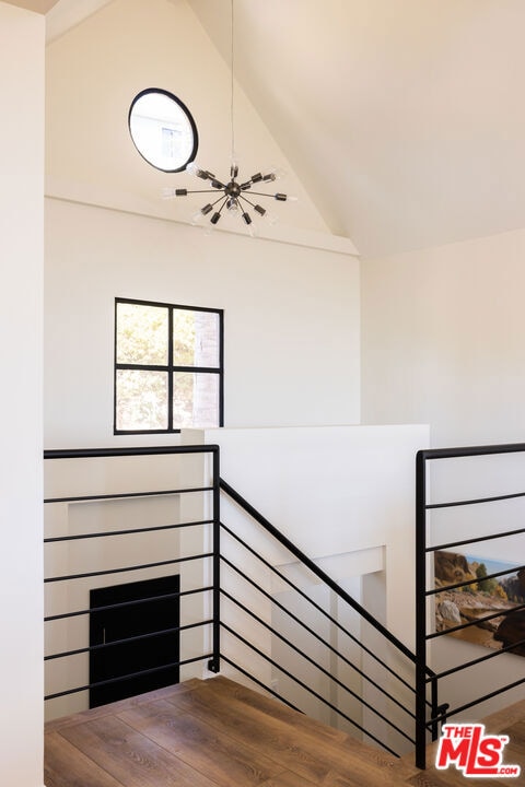 staircase featuring lofted ceiling and hardwood / wood-style floors