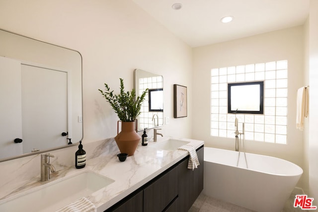 bathroom featuring vanity and a bath