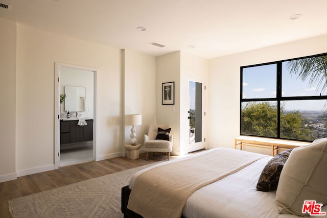 bedroom featuring hardwood / wood-style flooring and ensuite bathroom