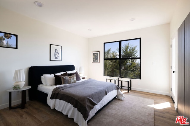 bedroom with dark wood-type flooring