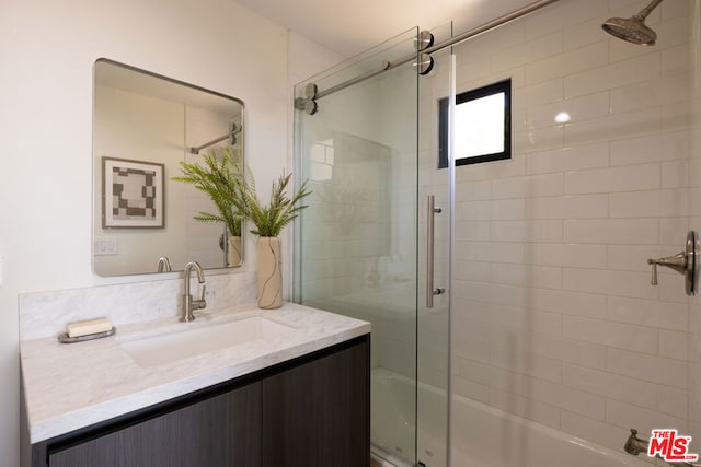 bathroom with bath / shower combo with glass door and vanity