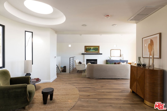 living room featuring a tray ceiling and hardwood / wood-style flooring