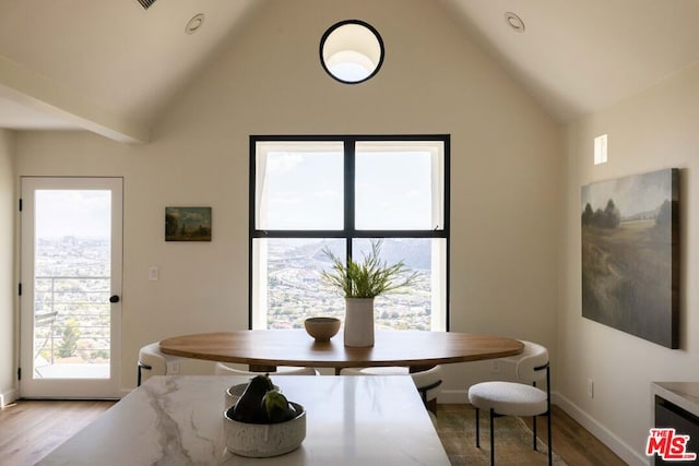 dining space featuring breakfast area, lofted ceiling, and light wood-type flooring