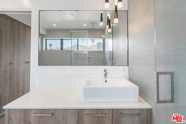 bathroom featuring vanity and tile walls