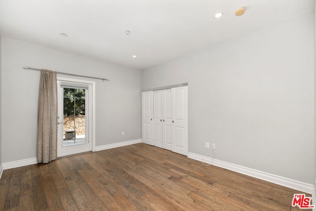 unfurnished bedroom featuring dark hardwood / wood-style flooring and a closet