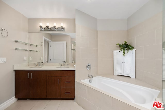 bathroom featuring vanity, tiled tub, and tile patterned flooring