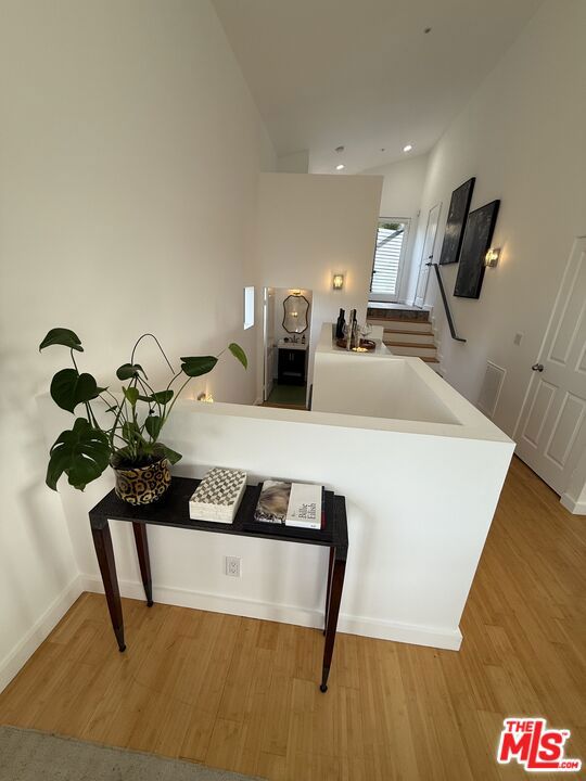 interior space with lofted ceiling, kitchen peninsula, and light hardwood / wood-style floors