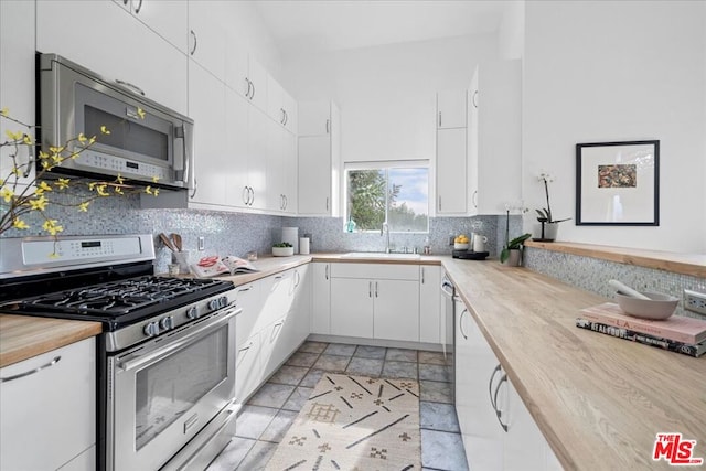 kitchen with white cabinetry, sink, decorative backsplash, and appliances with stainless steel finishes