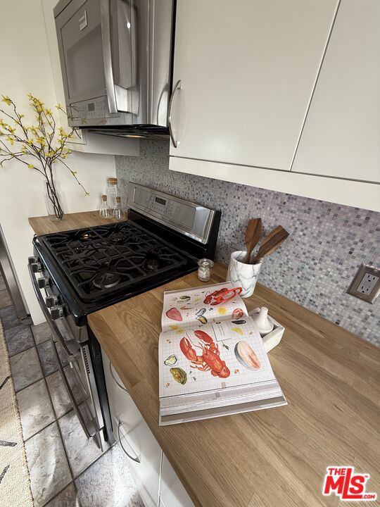 kitchen featuring gas range and decorative backsplash