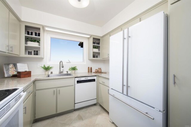 kitchen with light stone counters, sink, and white appliances