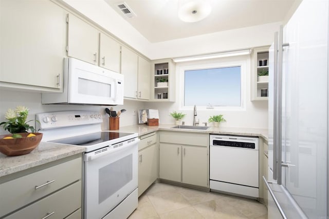 kitchen featuring light tile patterned flooring, sink, and white appliances