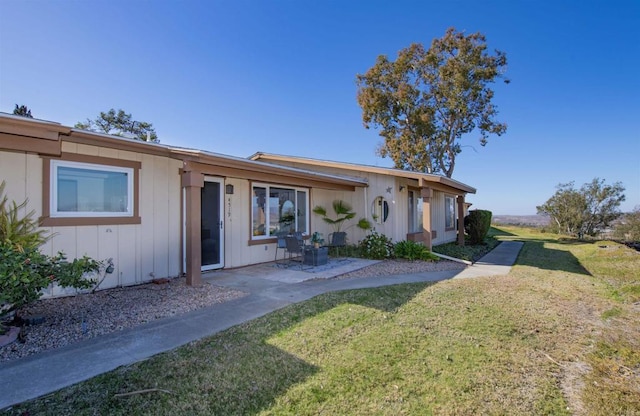 rear view of property with a lawn