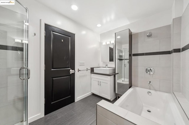 bathroom featuring shower with separate bathtub and vanity