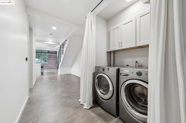 washroom featuring washer and clothes dryer and cabinets