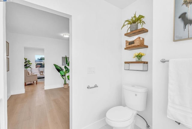 bathroom with hardwood / wood-style floors and toilet