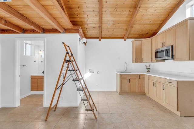 kitchen featuring beamed ceiling, light brown cabinetry, sink, and wooden ceiling