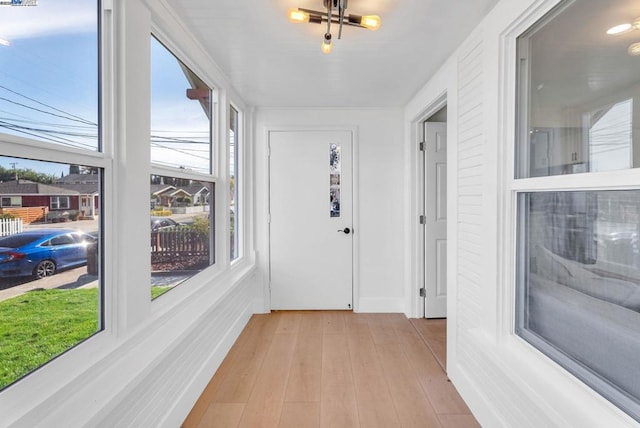 corridor with light hardwood / wood-style floors and a wealth of natural light