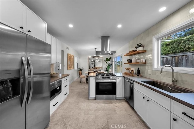 kitchen featuring white cabinetry, sink, backsplash, island exhaust hood, and stainless steel appliances