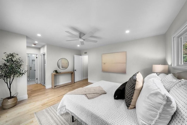 bedroom featuring ceiling fan, ensuite bathroom, and light hardwood / wood-style flooring