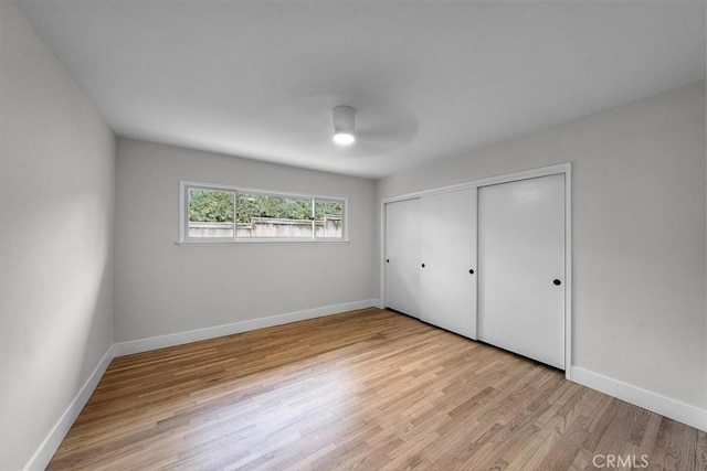 unfurnished bedroom with ceiling fan, light hardwood / wood-style floors, and a closet