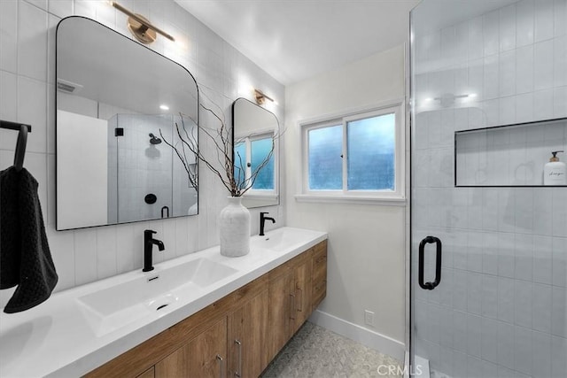 bathroom with vanity and a shower with door