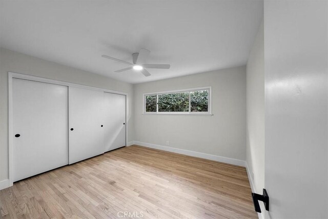 unfurnished bedroom with ceiling fan, a closet, and light hardwood / wood-style flooring