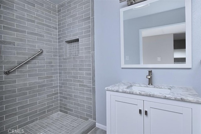 bathroom with vanity and a tile shower