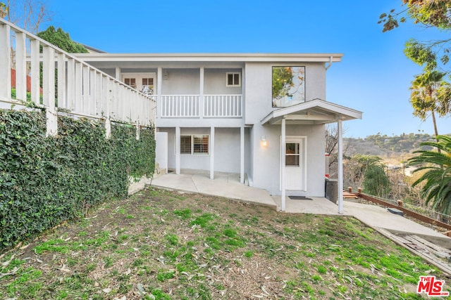 rear view of property with a balcony and a patio area