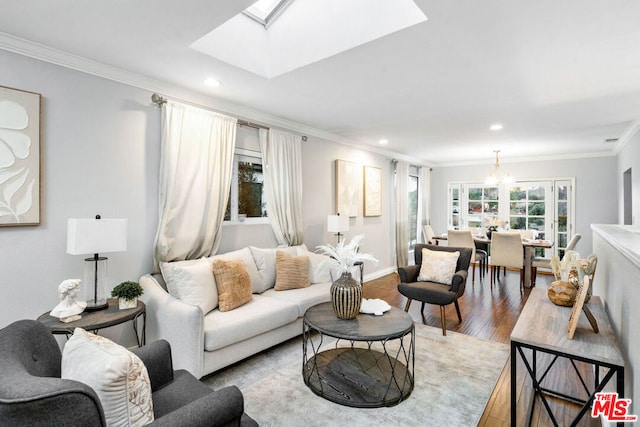 living room featuring ornamental molding, an inviting chandelier, light wood-type flooring, and a skylight