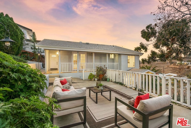 back house at dusk with an outdoor hangout area and a patio area