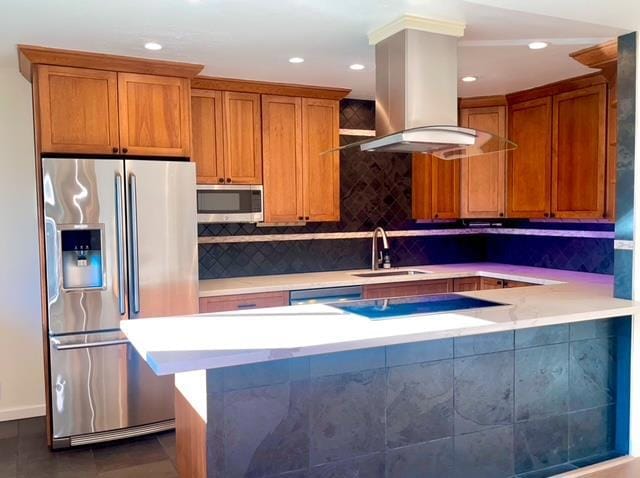 kitchen featuring sink, island range hood, appliances with stainless steel finishes, kitchen peninsula, and dark tile patterned floors