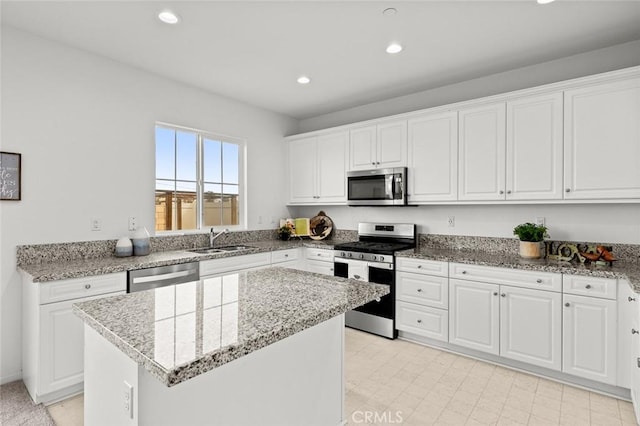 kitchen with white cabinetry, stainless steel appliances, and a center island