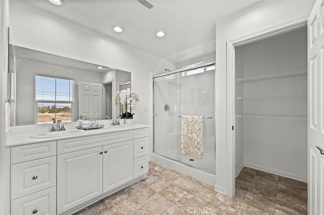 bathroom featuring vanity and a shower with door