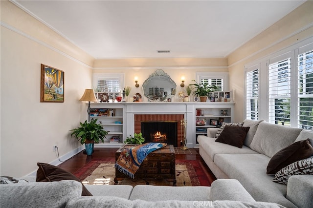 living room with hardwood / wood-style flooring, a fireplace, and crown molding