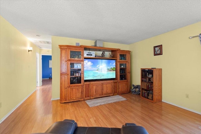 living room with light hardwood / wood-style floors and a textured ceiling