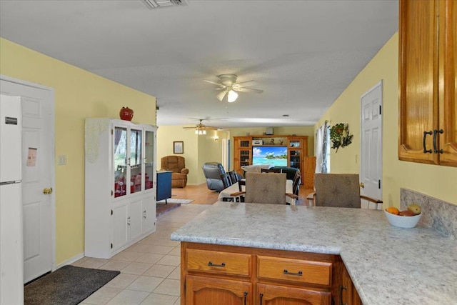 kitchen featuring white fridge, light tile patterned floors, and ceiling fan