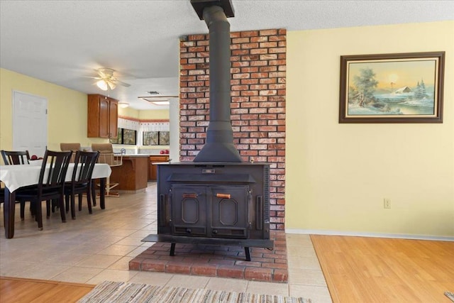 room details featuring hardwood / wood-style flooring, a wood stove, and ceiling fan