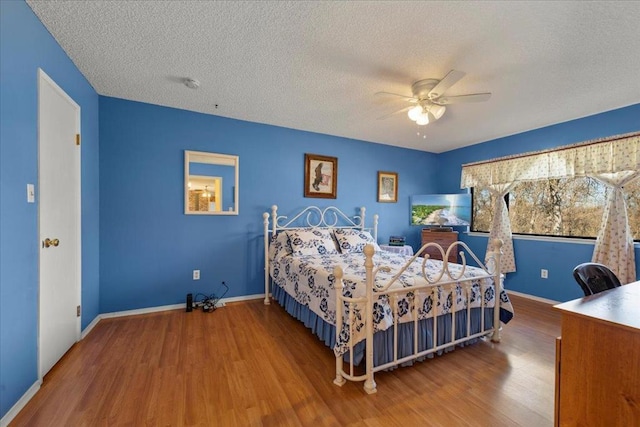 bedroom featuring hardwood / wood-style floors, a textured ceiling, and ceiling fan