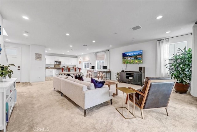 living area with recessed lighting, light colored carpet, and visible vents