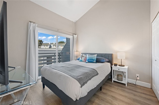 bedroom with vaulted ceiling and hardwood / wood-style floors